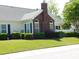 Backyard view showing brick chimney, green grass and mature shrubbery around the home at 8800 Dorchester Rd # 2902, North Charleston, SC 29420