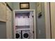 Bright laundry room with front load washer and dryer, storage, and laundry-themed decoration at 8800 Dorchester Rd # 2902, North Charleston, SC 29420