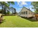 Well-manicured backyard with lush grass, mature trees, and a white home exterior at 924 Trowman Ln, Mount Pleasant, SC 29464