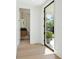 Entryway with light hardwood flooring, steel and glass door and view of half-bath with designer wallpaper at 924 Trowman Ln, Mount Pleasant, SC 29464