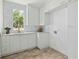 Bright laundry room with white cabinets, white tile, and modern fixtures at 924 Trowman Ln, Mount Pleasant, SC 29464