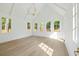 Bright living room with vaulted ceilings, wood floors, many windows, and modern chandelier at 924 Trowman Ln, Mount Pleasant, SC 29464