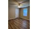A well-lit bedroom featuring a fan, wood floors, a window, and a door for a modern living space at 9914 Levenshall Dr, Ladson, SC 29456