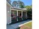 Inviting covered front porch with blooming flower bushes and classic architectural details at 9914 Levenshall Dr, Ladson, SC 29456