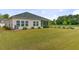 Expansive backyard with lush green lawn, complemented by a view of the screened porch and surrounding greenery at 1003 Locals St, Summerville, SC 29485