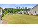 Spacious backyard with well-maintained lawn, landscaping, and neighborhood view at 1003 Locals St, Summerville, SC 29485