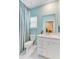 Bright bathroom featuring a vanity with white cabinets, a large mirror, and a shower-tub combo with blue curtain at 1003 Locals St, Summerville, SC 29485