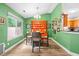 Cozy dining room with green walls, wood floors, and an orange hutch at 1016 Providence Way, Summerville, SC 29483