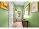 Hallway with green walls and a wood floor leading to a door with a view of the front yard at 1016 Providence Way, Summerville, SC 29483