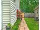A blooming rose bush lines a brick pathway leading to a gated backyard entrance at 1016 Providence Way, Summerville, SC 29483