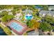 Aerial view of community pool with tennis courts, surrounded by mature trees, landscaping and residential buildings at 1025 Riverland Woods Pl # 1023, Charleston, SC 29412