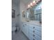 Bright bathroom with white vanity, updated fixtures, decorative mirror and a framed beach picture at 1025 Riverland Woods Pl # 1023, Charleston, SC 29412