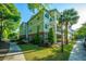 Green multi-story condo building with multiple balconies and verdant landscaping at 1025 Riverland Woods Pl # 1023, Charleston, SC 29412