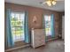 Bedroom with tan walls, ceiling fan, dresser, and two windows with blue curtains at 1097 Briar Rose Ln, Ladson, SC 29456