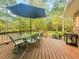 Outdoor living on back deck with patio furniture, lush green scenery and an umbrella for shade at 114 California Ave, Moncks Corner, SC 29461