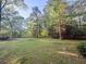 Lush backyard featuring green grass and perimeter fencing, offering ample space and privacy at 114 California Ave, Moncks Corner, SC 29461