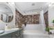 Bright bathroom features exposed brick, soaking tub with gold fixtures, and decorative storage at 114 California Ave, Moncks Corner, SC 29461