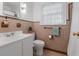 Traditional bathroom with a white sink, toilet, decorative wall tiles and a window providing natural light at 114 California Ave, Moncks Corner, SC 29461