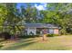 Brick home nestled among mature trees with a well-maintained lawn and a tidy brick walkway at 114 California Ave, Moncks Corner, SC 29461
