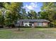 Charming brick home surrounded by mature trees, with a well-manicured lawn and a brick pathway at 114 California Ave, Moncks Corner, SC 29461