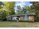 Charming brick home nestled among mature trees with a well-maintained lawn and manicured landscaping at 114 California Ave, Moncks Corner, SC 29461