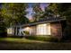 Classic brick home with mature trees, tidy landscaping, and welcoming front porch with picture window at 114 California Ave, Moncks Corner, SC 29461