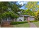 Beautiful brick home with a covered front porch, brick sidewalk, trimmed hedges, and mature landscaping at 114 California Ave, Moncks Corner, SC 29461
