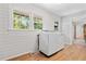 Bright laundry room featuring white washer and dryer, shiplap walls and wood-look flooring at 114 California Ave, Moncks Corner, SC 29461