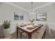 Bright dining room featuring a modern chandelier, table set for six, and vibrant abstract artwork at 1300 Park West Blvd # 101, Mount Pleasant, SC 29466
