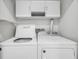 Clean, bright laundry room with modern washer, dryer, cabinets, and shelving units at 1300 Park West Blvd # 101, Mount Pleasant, SC 29466