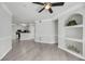 Open living room with hardwood floors, built-in shelving, and access to the kitchen at 1300 Park West Blvd # 101, Mount Pleasant, SC 29466