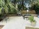 Community grill and picnic area with a charcoal grill, metal picnic table, and wrought iron bench seating at 1300 Park West Blvd # 406, Mount Pleasant, SC 29466