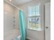 Bathroom featuring bathtub with shower, blue curtain, window, and adjacent dual sinks at 131 Buchanan Cir, Goose Creek, SC 29445