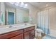 Bright bathroom with a double sink vanity and a tub with a blue and white striped shower curtain at 131 Buchanan Cir, Goose Creek, SC 29445