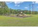 Community playground with swings and slides, set on a grassy area with a wooded backdrop at 131 Buchanan Cir, Goose Creek, SC 29445
