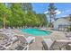 Community pool featuring ample lounge chairs, umbrellas, and seating amidst a lush, wooded setting at 131 Buchanan Cir, Goose Creek, SC 29445