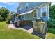 Spacious backyard with outdoor kitchen, stone patio, and white Adirondack chairs under an awning at 1325 Whisker Pole Ln, Mount Pleasant, SC 29466
