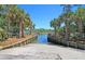 Concrete boat ramp leads to a serene river, surrounded by palm trees and wooden bulkheads, perfect for water enthusiasts at 1325 Whisker Pole Ln, Mount Pleasant, SC 29466