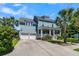 Charming two-story blue home features a welcoming front porch, palm trees, and a two-car garage at 1325 Whisker Pole Ln, Mount Pleasant, SC 29466