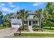 Charming two-story blue home features a welcoming front porch, well-manicured lawn, and two-car garage at 1325 Whisker Pole Ln, Mount Pleasant, SC 29466