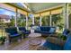 Inviting sunroom featuring wicker furniture with blue cushions and views of lush greenery at 1325 Whisker Pole Ln, Mount Pleasant, SC 29466