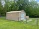 Exterior of the large, metal storage shed with roll-up door in fenced backyard at 136 Gailmoor Dr, Ladson, SC 29456