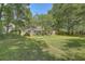 Fenced backyard providing privacy, with a grassy lawn and mature trees, ideal for relaxation at 141 Bridgecreek Dr, Goose Creek, SC 29445