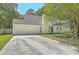 Charming home with two-car garage and long driveway, complemented by mature trees and blue accents at 141 Bridgecreek Dr, Goose Creek, SC 29445