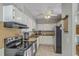 Functional kitchen featuring white cabinets, black appliances, and a ceiling fan, perfect for everyday meal preparation at 141 Bridgecreek Dr, Goose Creek, SC 29445