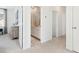 Bright hallway view leading to bathroom with white cabinets and light marble floors in a modern home at 1427 Clay Field Trl, Summerville, SC 29485