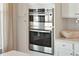 Stainless steel double oven is encased in white cabinets with white tile backsplash at 1427 Clay Field Trl, Summerville, SC 29485