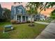 A beautifully landscaped home showcasing a tidy front yard with a palm tree and colorful flower beds at 145 Basket Grass Ln, Summerville, SC 29486