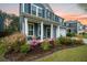Inviting exterior view with a covered porch and a charming garden featuring vibrant flowers and greenery at 145 Basket Grass Ln, Summerville, SC 29486