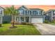 Charming two-story home featuring a well-manicured lawn and a cozy front porch with lush landscaping at 145 Basket Grass Ln, Summerville, SC 29486